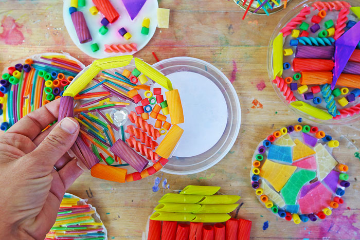 Make this colorful suncatcher craft using dyed pasta and glue.